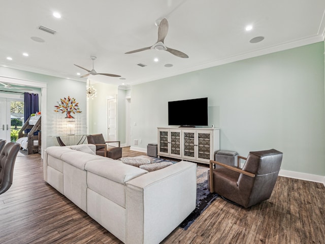 living room featuring wood finished floors, ornamental molding, and visible vents