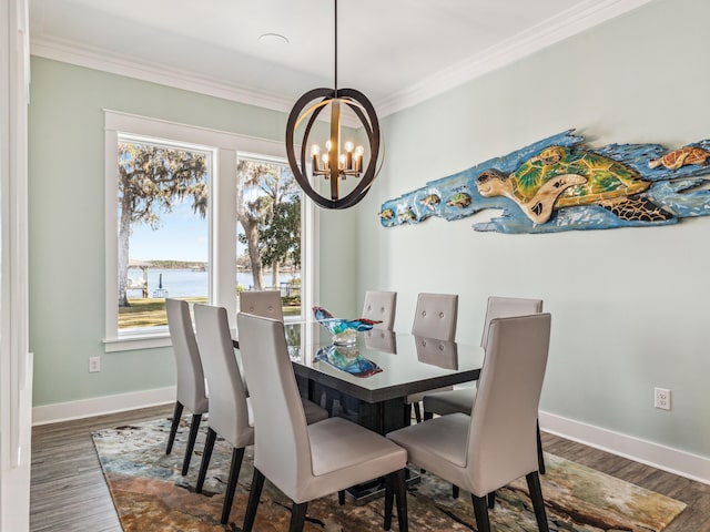 dining area featuring wood finished floors, baseboards, a water view, ornamental molding, and an inviting chandelier