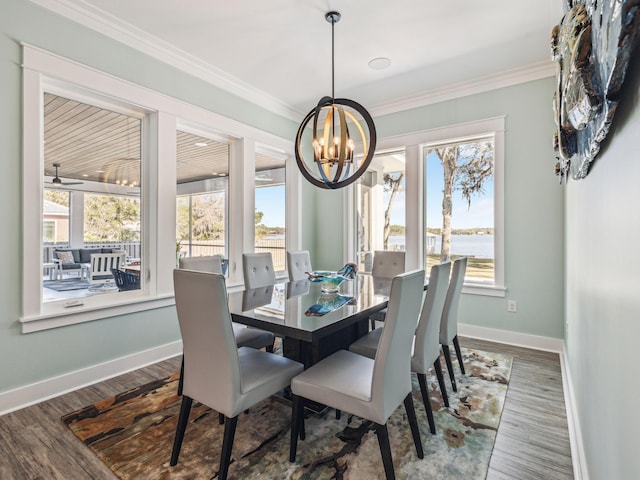 dining room featuring ornamental molding, wood finished floors, a notable chandelier, and plenty of natural light