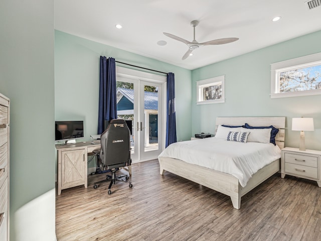 bedroom with multiple windows, access to exterior, wood finished floors, and french doors