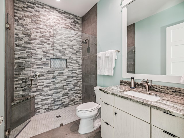 bathroom featuring a shower stall, toilet, tile patterned flooring, and vanity