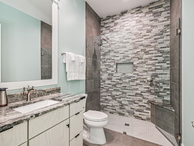 bathroom featuring a stall shower, toilet, tile patterned flooring, and vanity