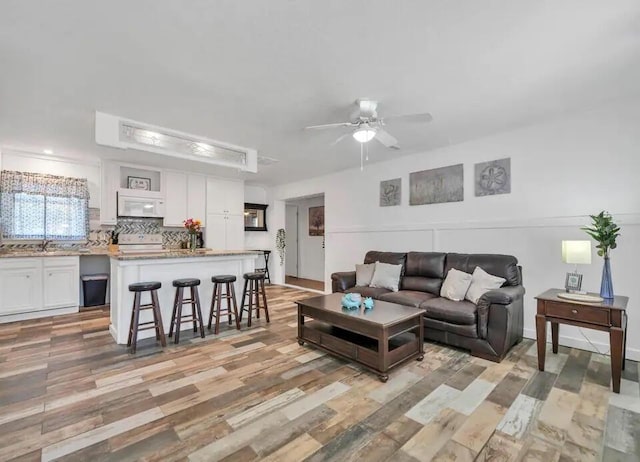 living room featuring light wood-style flooring and a ceiling fan