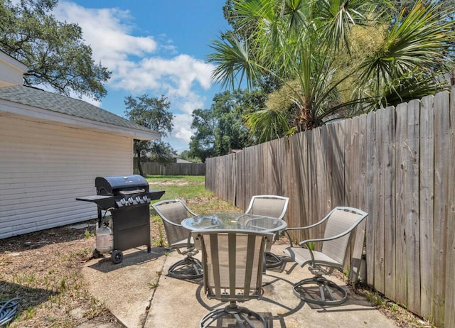 view of patio featuring area for grilling, outdoor dining space, and fence