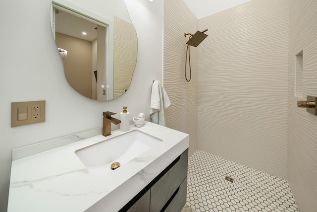 full bath with a tile shower and vanity