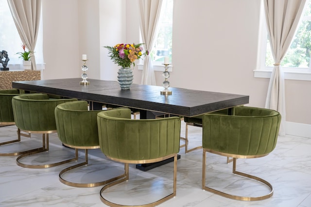 dining space featuring a wealth of natural light and marble finish floor