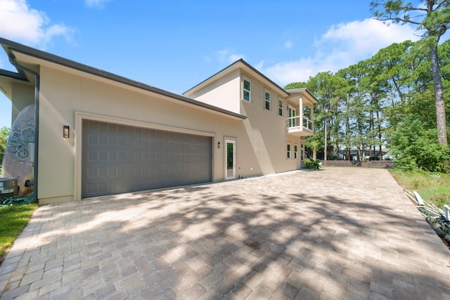 view of front facade with driveway, stucco siding, and an attached garage