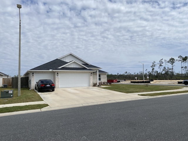 3784 Redbud Way, Panama City, FL 32404 - view of front of property with a front yard, concrete driveway, fence, an attached garage, and brick siding