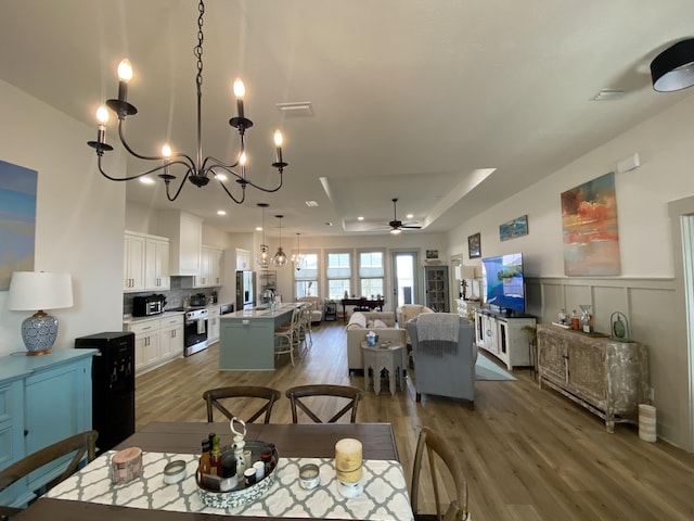3784 Redbud Way, Panama City, FL 32404 - dining space with a wainscoted wall, wood finished floors, a decorative wall, ceiling fan with notable chandelier, and visible vents
