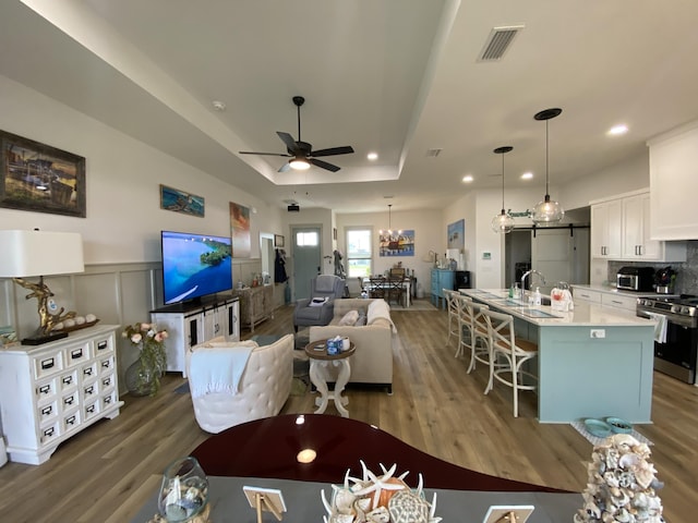 3784 Redbud Way, Panama City, FL 32404 - living area with a tray ceiling, visible vents, ceiling fan with notable chandelier, and wood finished floors