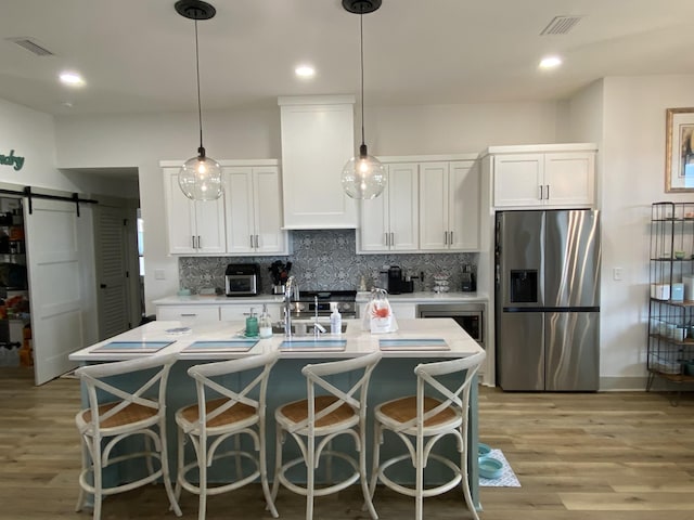 3784 Redbud Way, Panama City, FL 32404 - kitchen with a barn door, visible vents, stainless steel appliances, and light wood-type flooring