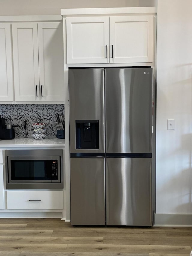 3784 Redbud Way, Panama City, FL 32404 - kitchen with white cabinets, light wood-style flooring, and appliances with stainless steel finishes
