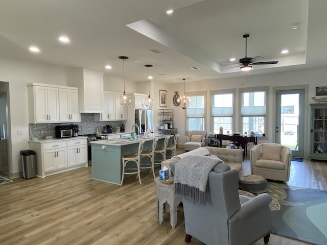3784 Redbud Way, Panama City, FL 32404 - living area featuring a raised ceiling, light wood-style flooring, ceiling fan with notable chandelier, visible vents, and recessed lighting