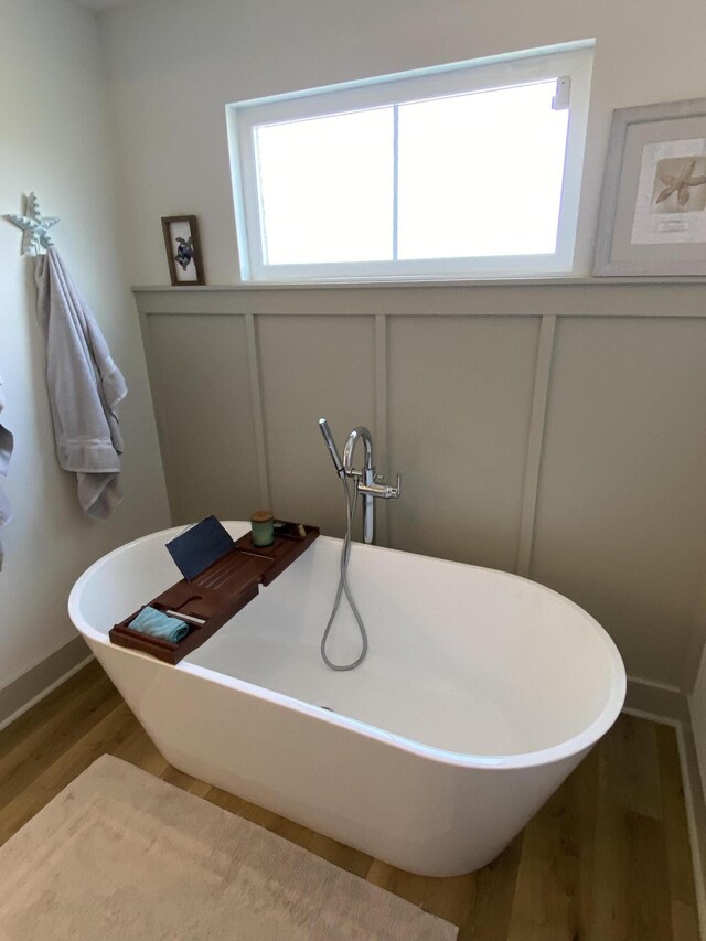 3784 Redbud Way, Panama City, FL 32404 - bathroom featuring a decorative wall, wood finished floors, and a freestanding tub