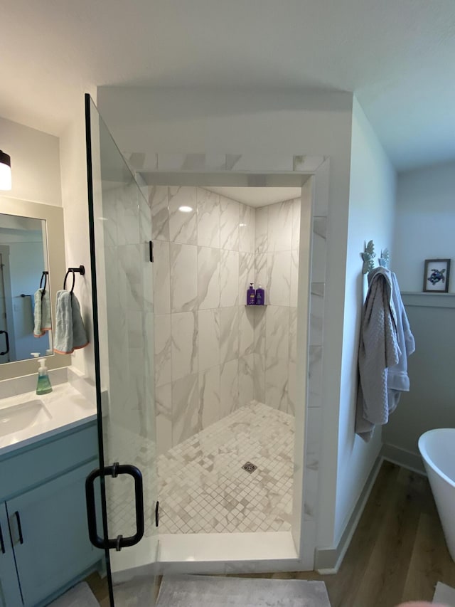 3784 Redbud Way, Panama City, FL 32404 - bathroom featuring vanity, a shower stall, wood finished floors, a soaking tub, and baseboards