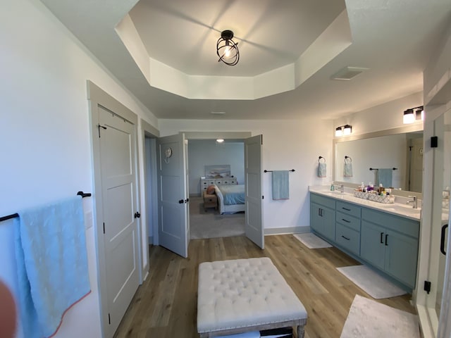 3784 Redbud Way, Panama City, FL 32404 - bathroom with a sink, double vanity, a tray ceiling, and wood finished floors