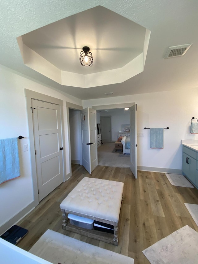 3784 Redbud Way, Panama City, FL 32404 - bedroom featuring a tray ceiling, baseboards, visible vents, and light wood-style floors