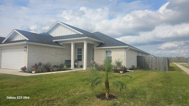 3784 Redbud Way, Panama City, FL 32404 - view of front of house with board and batten siding, brick siding, a front yard, and an attached garage