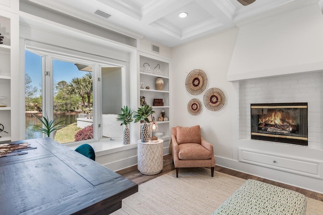 living area featuring coffered ceiling, visible vents, and wood finished floors