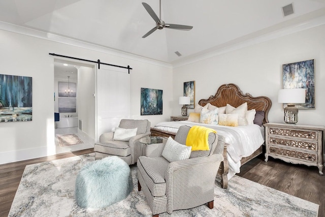 bedroom featuring a barn door, visible vents, vaulted ceiling, and wood finished floors