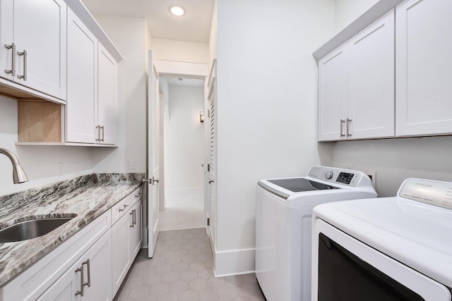 laundry room featuring washer and clothes dryer, a sink, light tile patterned floors, baseboards, and cabinet space
