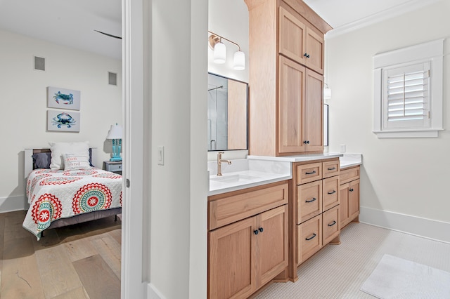 bathroom featuring vanity, crown molding, baseboards, visible vents, and wood finished floors