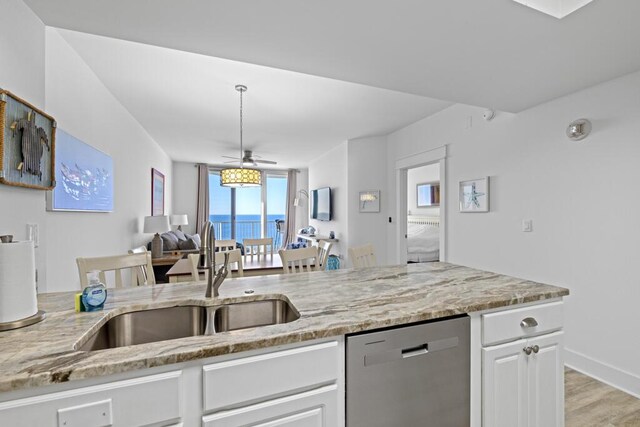8575 Gulf Blvd Unit 1402, Navarre, FL 32566 - kitchen with open floor plan, a sink, light stone counters, dishwasher, and white cabinets