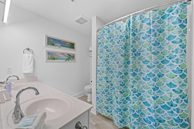 8575 Gulf Blvd Unit 1402, Navarre, FL 32566 - bathroom featuring wood finished floors, toilet, vanity, and a shower with curtain