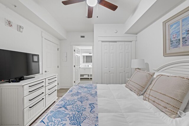 8575 Gulf Blvd Unit 1402, Navarre, FL 32566 - bedroom featuring a closet, baseboards, a ceiling fan, light wood-style floors, and ensuite bath