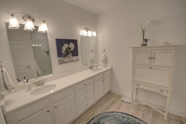 148 Piper Cv, Santa Rosa Beach, FL 32459 - full bath featuring a shower with door, wood finished floors, a sink, and double vanity