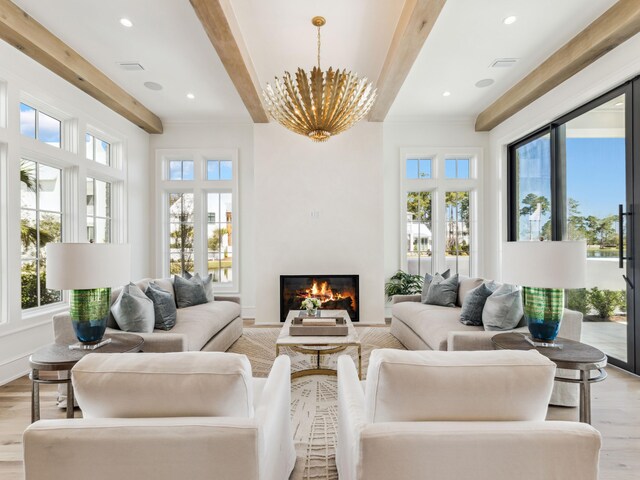 267 Tyler Dr, Santa Rosa Beach, FL 32459 - living room featuring light wood-type flooring, beam ceiling, a glass covered fireplace, and an inviting chandelier