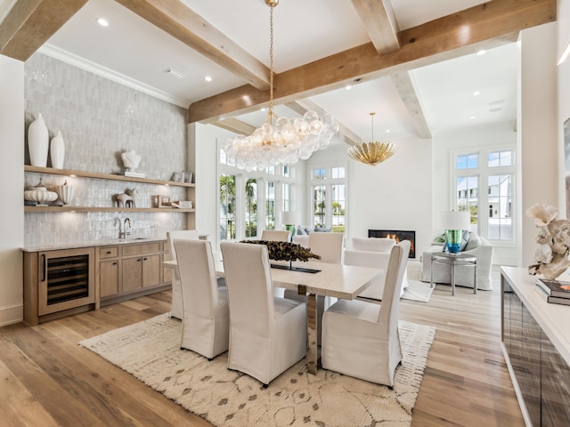 267 Tyler Dr, Santa Rosa Beach, FL 32459 - dining space featuring beamed ceiling, wine cooler, a glass covered fireplace, and light wood-style floors