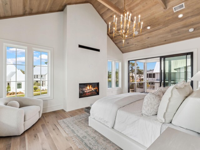 267 Tyler Dr, Santa Rosa Beach, FL 32459 - bedroom with an inviting chandelier, wooden ceiling, high vaulted ceiling, light wood-style floors, and a glass covered fireplace