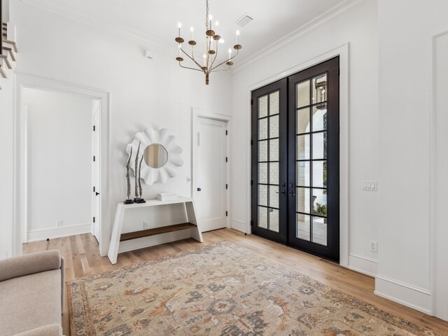 267 Tyler Dr, Santa Rosa Beach, FL 32459 - foyer entrance with visible vents, crown molding, french doors, and an inviting chandelier