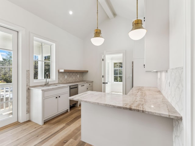267 Tyler Dr, Santa Rosa Beach, FL 32459 - kitchen with white cabinetry, tasteful backsplash, a sink, light wood-style flooring, and a peninsula