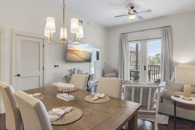 dining space with ceiling fan with notable chandelier, visible vents, and wood finished floors