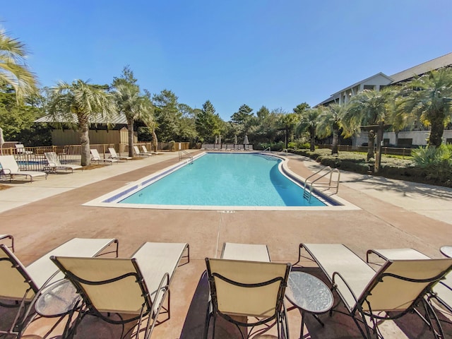 pool featuring fence and a patio area