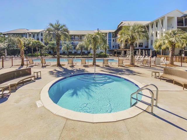 pool with fence and a patio area