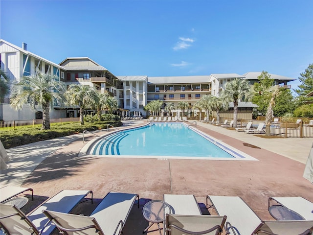 pool featuring fence and a patio