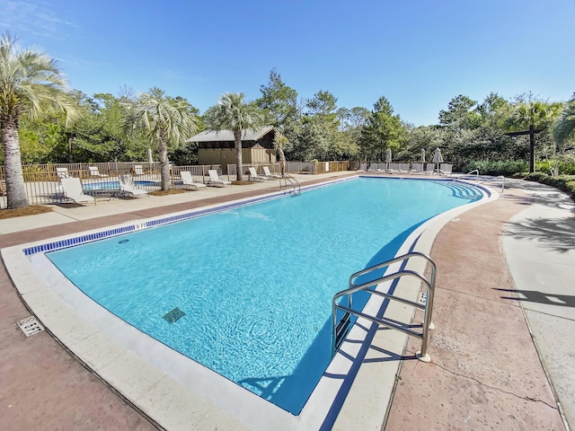 pool featuring fence and a patio area