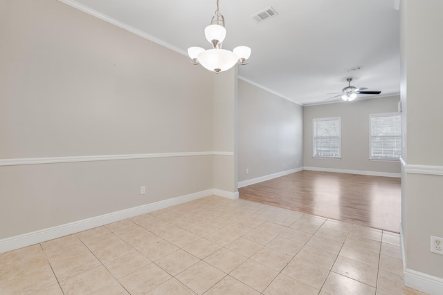 empty room with visible vents, ornamental molding, ceiling fan with notable chandelier, light tile patterned floors, and baseboards