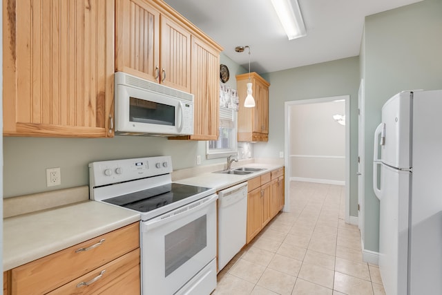 kitchen with a sink, white appliances, light countertops, and light tile patterned floors