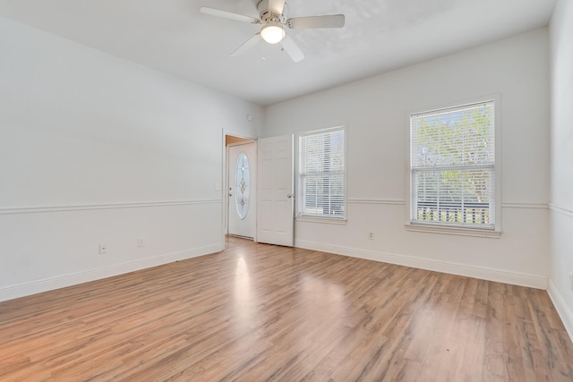 empty room featuring light wood-style flooring, baseboards, and ceiling fan