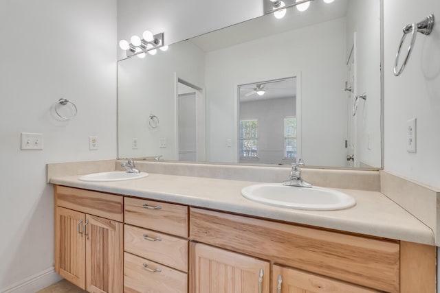 bathroom with double vanity, a ceiling fan, and a sink