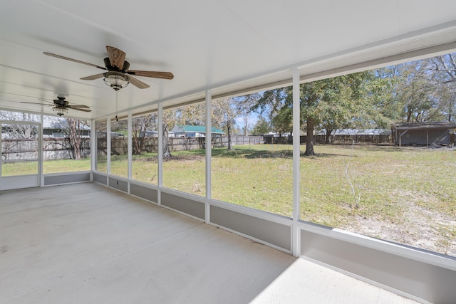 unfurnished sunroom featuring ceiling fan