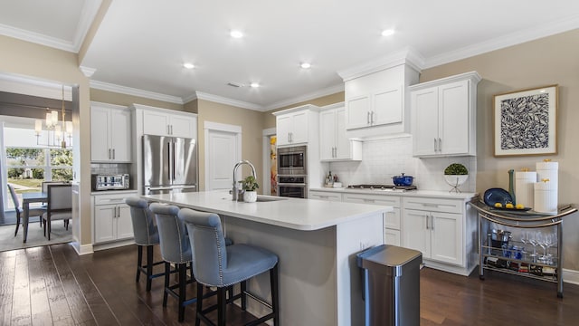 kitchen featuring dark wood finished floors, a breakfast bar, a sink, and stainless steel appliances