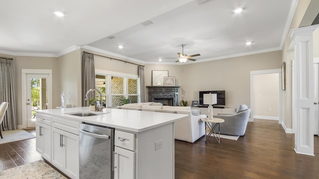 kitchen with dark wood-style flooring, stainless steel dishwasher, a sink, a ceiling fan, and a fireplace