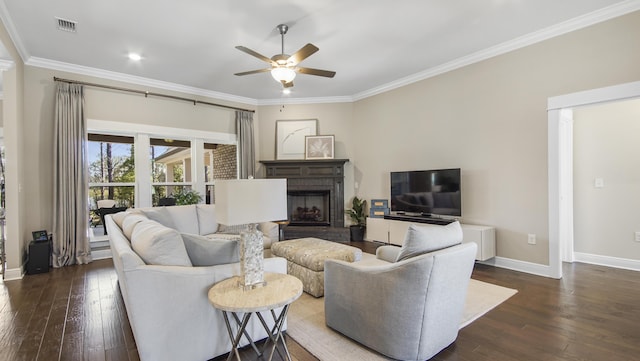 living room featuring a brick fireplace, ornamental molding, hardwood / wood-style flooring, and ceiling fan