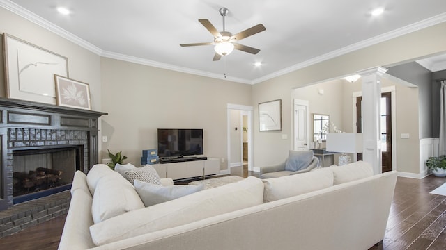 living room with dark wood-style floors, ceiling fan, a brick fireplace, and ornamental molding