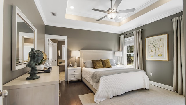 bedroom featuring dark wood-style flooring, baseboards, ornamental molding, a ceiling fan, and a raised ceiling